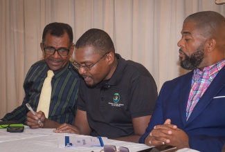 Minister without Portfolio in the Ministry of Economic Growth and Job Creation with Responsibility for Works, Hon. Robert Morgan (centre), converses with President, St. Catherine Chamber of Commerce and Industry, Dennis Robotham (left), on Wednesday (April 30) during the organisation’s monthly meeting at Cecil’s Restaurant in Spanish Town. Listening is Vice President, Marvin Hayden.
