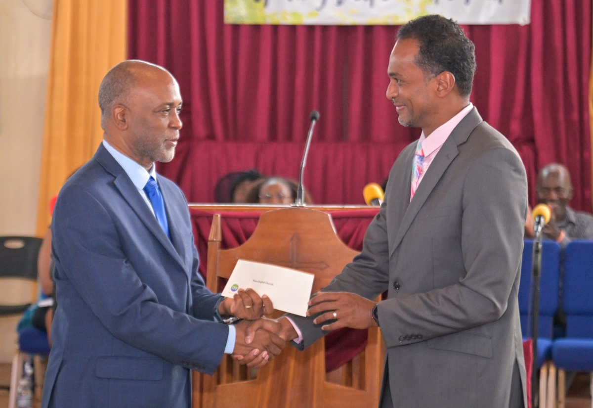 Executive Director of the Tourism Enhancement Fund, Dr. Carey Wallace (right) presents a donation to Pastor, Mona Baptist Church, Rev. Dr.  Stephen Jennings, during at the Tourism Enhancement Fund’s 20th Anniversary Church Service held today (May 18) at the Mona Baptist Church in Kingston. It was held under the theme '20 Years of Impact: Tourism Dollars Still Working for You'.