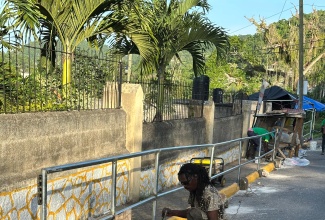 A volunteer installs guardrails at Brown’s Town Primary School in St. Ann on Labour Day (May 23) to enhance student safety.