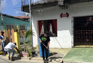 Mayor of Morant Bay, Councillor Louis Chin, participates in the cleaning of Queen Street, during Labour Day activities in St. Thomas on Friday , May 23.