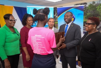 Commissioner of Corrections, Brigadier (rt’d) Radgh Mason (second right), presents a trophy to the Most Behaving Ward, at the recent official launch of the Positive Behaviour Management Standard Operating Procedures (SOP) Manual, at the Rio Cobre Juvenile Correctional Centre in Spanish Town, St. Catherine. Others pictured (from left) are Superintendent in charge of the Rio Cobre Centre, Maulette White; Director of Juvenile Services at the Department of Correctional Services (DCS), Claudeth Hamilton; Deputy Country Representative of the United Nations Children's Fund (UNICEF), Muhammad Mohiuddin, and Chief Technical Director in the Ministry of National Security, Shauna Trowers.

