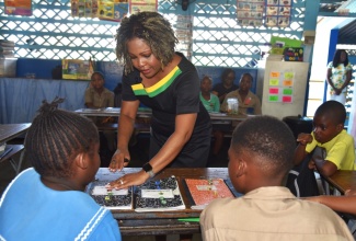 Minister of Education, Skills, Youth & Information, Senator Dr. the Hon. Dana Morris Dixon (centre), engages in a lesson with students at Clan Carthy Primary School in Kingston in May.

