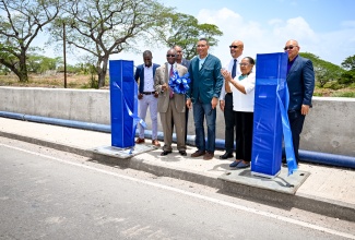 Prime Minister, Dr. the Most Hon. Andrew Holness (centre), cuts the ribbon to officially hand over the Myton Gully Drainage Improvement Project in a ceremony on Tuesday (June 10), in Old Harbour, St. Catherine. Also participating are (from left) Project Manager for the Disaster Vulnerability Reduction Project (DVRP), Dane McLean; Managing Director of Jamaica Social Investment Fund (JSIF), Omar Sweeney; Member of Parliament for St. Catherine South Western, Everald Warmington; Senior Environmental Specialist, World Bank Group, Kirk Brown; Custos Rotulorum for St. Catherine, Hon. Icilyn Golding; and General Manager of Finance, Procurement and Standard at JSIF, Orville Hill.