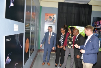 Executive Director of the Institute of Jamaica (IOJ), Michele Creed-Nelson (centre) and Chief Executive Officer of the National Environment and Planning Agency (NEPA), Leonard Francis (second right), look on as Director of Endangered Species Intervention at Bat Conservation International, Jon Flanders (right), highlights features of a bat exhibit titled ‘Guardians of the Night: Celebrating Jamaica’s Remarkable Bats’ during the launch on Wednesday (June 18), at the Institute of Jamaica (IOJ) in downtown Kingston. Also observing are Chief of Conservation and Global Strategy, BCI, Kevin Pierson (left), and Director of the Natural History Museum of Jamaica (NHMJ), Tracy Commock.  The exhibition, mounted by the Natural History Museum of Jamaica (NHMJ), highlights the island’s diverse bat population, including two critically endangered species that inhabit only a few cave locations across the country.

