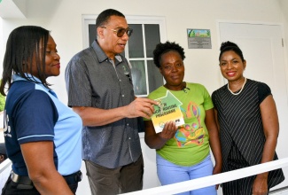 Prime Minister, Dr. the Most Hon. Andrew Holness, presents New Social Housing Programme (NSHP) beneficiary, Gloria Dacres (second right), with the keys to her new two-bedroom home in Amity Hall, St. Thomas Eastern, on June 19. Also participating in the proceedings are (from left) Permanent Secretary in the Ministry of Economic Growth and Job Creation, Arlene Williams, and Member of Parliament for St. Thomas Eastern, Dr. Michelle Charles.

