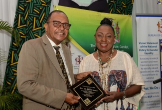 Minister of Culture, Gender, Entertainment and Sport, Hon. Olivia Grange, presents the Outstanding Father Award to Rev. Dr. Peter Garth, at a ceremony held at the Caymanas Golf Club in St. Catherine in June 2022.