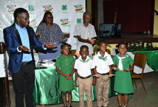 St. Ann 4-H Clubs Parish Manager, Tedroy Gordon (left), engages in an activity with Clubbites from Brown’s Town Model Infant School during the St. Ann 4-H Clubs’ Annual General Meeting and Awards Ceremony at Brown’s Town Methodist Church on June 25. In the background (from left) are 2025 parish Leader of the Year awardee, Nicolette Fisher from Runaway Bay Primary and Infant School, and Chairman of the Parish Advisory Council, Lambert Russell.