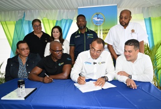 Health and Wellness Minister, Dr. the Hon. Christopher Tufton (seated, second right), sign a contract for the new $818.5 million Ocho Rios Health Centre in St. Ann on Friday, (June 27). looking on are (seated from left) North East Regional Health Authority (NERHA) Regional Director, Fabia Lamm; Managing Director of Cenitech Engineering Solutions Limited, George Knight; and Member of Parliament for St. Ann North East, Hon. Matthew Samuda. Also, observing (standing, from left) are Custos Rotulorum of St Ann, Joseph Issa; Board Chairman of the North East Regional Health Authority (NERHA), Laura Heron; Programme Manager for Health Systems Strengthening Programme (HSSP), Orett Clarke; and Mayor of St. Ann