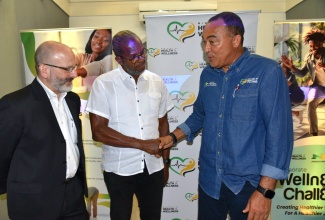 Minister of Health and Wellness, Dr. the Hon. Christopher Tufton (left), greets Running Events Jamaica Founder, Alfred “Frano” Francis, during Thursday’s (June 19) launch of the Ministry’s ‘Corporate Wellness Challenge – 8×8 Edition’ at Devon House in Kingston. Looking on is Pan American Health Organization (PAHO)/World Health Organization (WHO) Representative to Jamaica, Bermuda and the Cayman Islands, Ian Stein.

