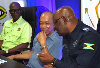 Deputy Prime Minister and Minister of National Security, Hon. Dr. Horace Chang (centre), in discussion with Assistant Commissioner of Police and Commanding Officer, Area 4, Michael Phipps, during the opening of the Denham Town JamaicaEye Monitoring Centre, at the Denham Town Police Station in Kingston, recently. At left is Minister of Local Government and Community Development, and Member of Parliament, Kingston Western,  Hon. Desmond McKenzie.

