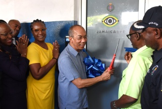 Deputy Prime Minister and Minister of National Security, Hon. Dr. Horace Chang (third right), cuts the ribbon symbolising the official opening of the Denham Town JamaicaEye Monitoring Centre at the Denham Town Police Station in downtown Kingston on Thursday (June 5). He is joined by (from left) Chairman of the Jamaica Police Federation, Sergeant Arlene McBean; Permanent Secretary in the Ministry of National Security, Ambassador Alison Stone Roofe; Minister of Local Government and Community Development, Hon. Desmond McKenzie; and Assistant Commissioner of Police, Commanding Officer, Area Four, Michael Phipps.

