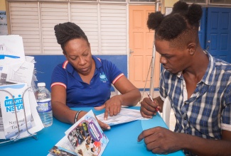Recruitment Officer at HEART/NSTA Trust’s Kingston Parish Office, Nerva Davis, assists Nathan Sewell with his application to enrol in one of the institution’s training programmes during a recent Education and Career Expo at the North Street Seventh-day Adventist Church.