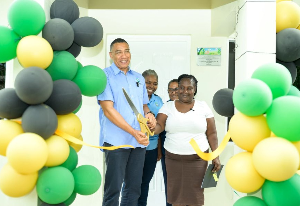 Prime Minister, Dr. the Most Hon. Andrew Holness (left) officially cuts the ribbon to hand over a New Social Housing Programme (NSHP) unit to beneficiary, Precious Eason (right) in Freeman