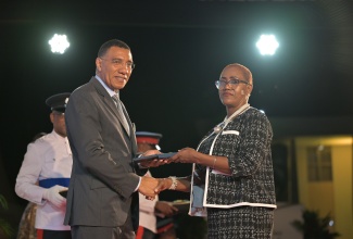Prime Minister, Dr. the Most Hon. Andrew Holness, presents Head of the Home Economics Department at Wycliffe Martin High School, Michelle Carlene Gordon, with the Prime Minister’s Medal of Appreciation for Service to Education, at Jamaica House, on May 28.