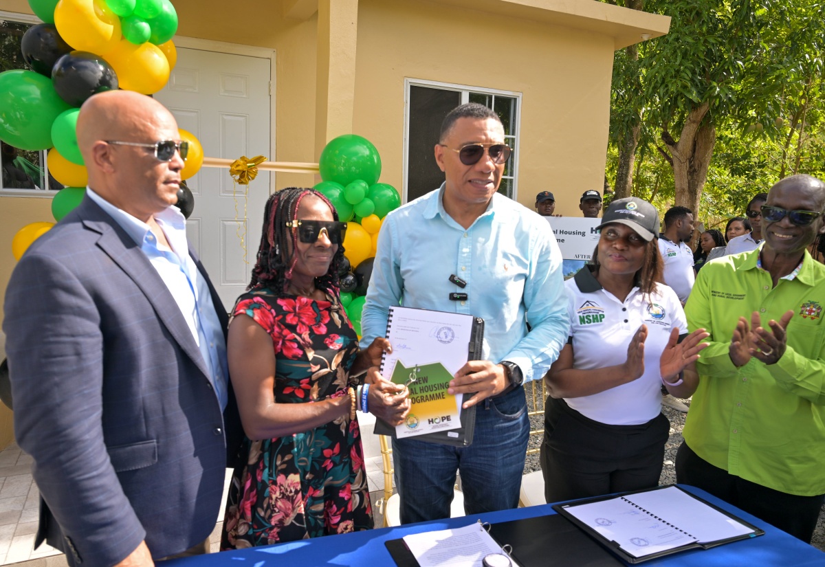 Prime Minister, Dr. the Most Hon. Andrew Holness (centre), hands New Social Housing Programme (NSHP) beneficiary, Elaine Bennett (second left), the social contract and keys to her new house in Lloyd’s District in St. Thomas recently. Sharing the moment (from left) are Member of Parliament for St. Thomas Western, James Robertson; Permanent Secretary in the Ministry of Economic Growth and Job Creation, Arlene Williams; and Minister of Local Government and Community Development, Hon. Desmond McKenzie.