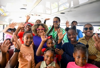 Minister of Education, Skills, Youth and Information, Senator Dr. the Hon. Dana Morris Dixon (second left), and Speaker of the House of Representatives and Member of Parliament for St. Andrew East Rural, Most Hon. Juliet Holness (centre), are surrounded by students of the Louise Bennett-Coverley Primary School aboard one of the buses that will be used in the Government’s Rural School Bus Programme. The students got the opportunity to ride aboard two of the buses to the Logos Hope book fair at the Cement Coal Pier in Kingston on Wednesday (July 23). Accompanying the students were principal, Sheena Taylor Morgan (right) and teachers at the institution.