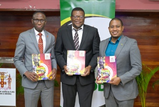 Minister of Agriculture, Fisheries and Mining, Hon. Floyd Green (right), joins President of the College of Agriculture, Science and Education (CASE), Dr. Derrick Deslandes (centre), and Provost and Senior Vice President for Academic Affairs for Tuskegee University College of Veterinary Medicine (TUCVM) in the United States, Dr. Thierno Thiam, in displaying the signed Memorandum of Understanding (MOU), which will enhance academic and professional training in veterinary studies at the institutions. The signing took place on Thursday (July 17) at the Ministry’s Old Hope Road offices in Kingston. 