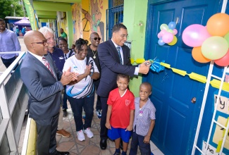 Prime Minister, Dr. the Most Hon. Andrew Holness, cuts the ribbon to officially open a technology room at Seaward Primary and Infant School in St. Andrew. He is joined by (from left) Chief Executive Officer, e-Learning Jamaica Company Limited, Andrew Lee; Chairman of the School Board, Bruce Bicknell; Principal, Arlene Reid, students at the institution and other representatives.

