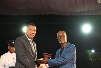Prime Minister, Dr. the Most Hon. Andrew Holness (left), presents the 2025 Prime Minister’s Medal of Appreciation for Service to Education to Geography Lecturer, Anthony Norman, during the awards ceremony at Jamaica House in May.