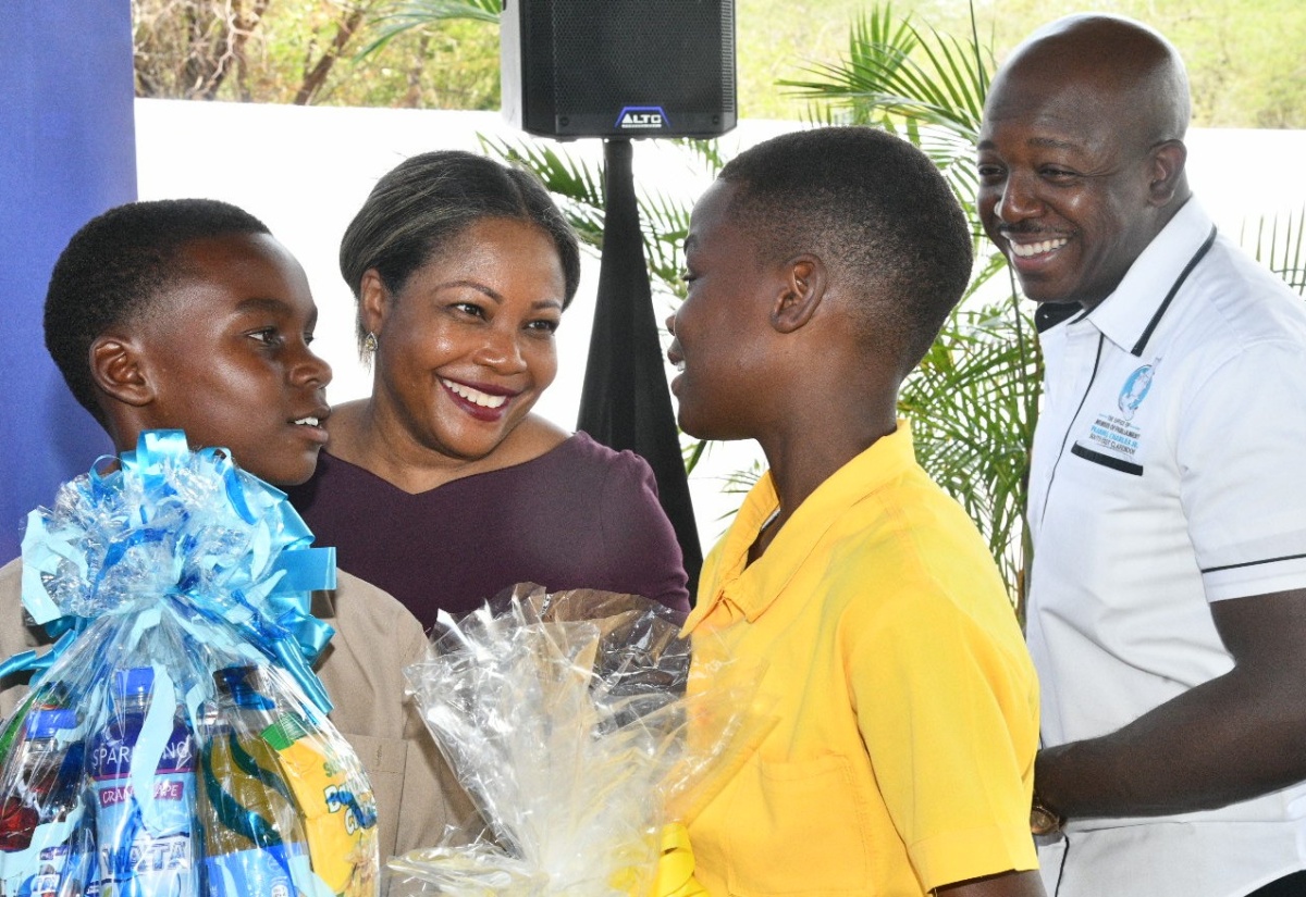 Minister of Education, Skills, Youth and Information, Senator Dr. the Hon. Dana Morris Dixon (second left), interacts with students from Mount Airy Primary School, Craigoy Carty (left) and Jamie Bailey (second right), at the Clarendon South Eastern Career Fair held at the Green Park Primary School, Sandy Bay, Clarendon, on July 4. Looking on is Minister of Labour and Social Security and Member of Parliament for the area, Hon. Pearnel Charles Jr.