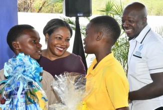 Minister of Education, Skills, Youth and Information, Senator Dr. the Hon. Dana Morris Dixon (second left), interacts with students from Mount Airy Primary School, Craigoy Carty (left) and Jamie Bailey (second right), at the Clarendon South Eastern Career Fair held at the Green Park Primary School, Sandy Bay, Clarendon, on July 4. Looking on is Minister of Labour and Social Security and Member of Parliament for the area, Hon. Pearnel Charles Jr.