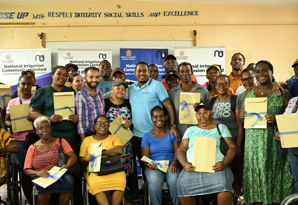 Minister of Agriculture, Fisheries and Mining, Hon. Floyd Green (centre), shares a moment with south St. Elizabeth farmers, who have received land titles under the Pedro Plains Irrigation Expansion Project. The documents were handed over on Tuesday (July 22) at the Newell High School in the parish.


