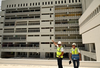 Minister of Health and Wellness, Dr. the Hon. Christopher Tufton (left), is joined by Project Manager for the Cornwall Regional Hospital’s redevelopment, Vivian Gordon, during a tour of the Type A institution in Montego Bay, St. James, on Saturday (July 5).