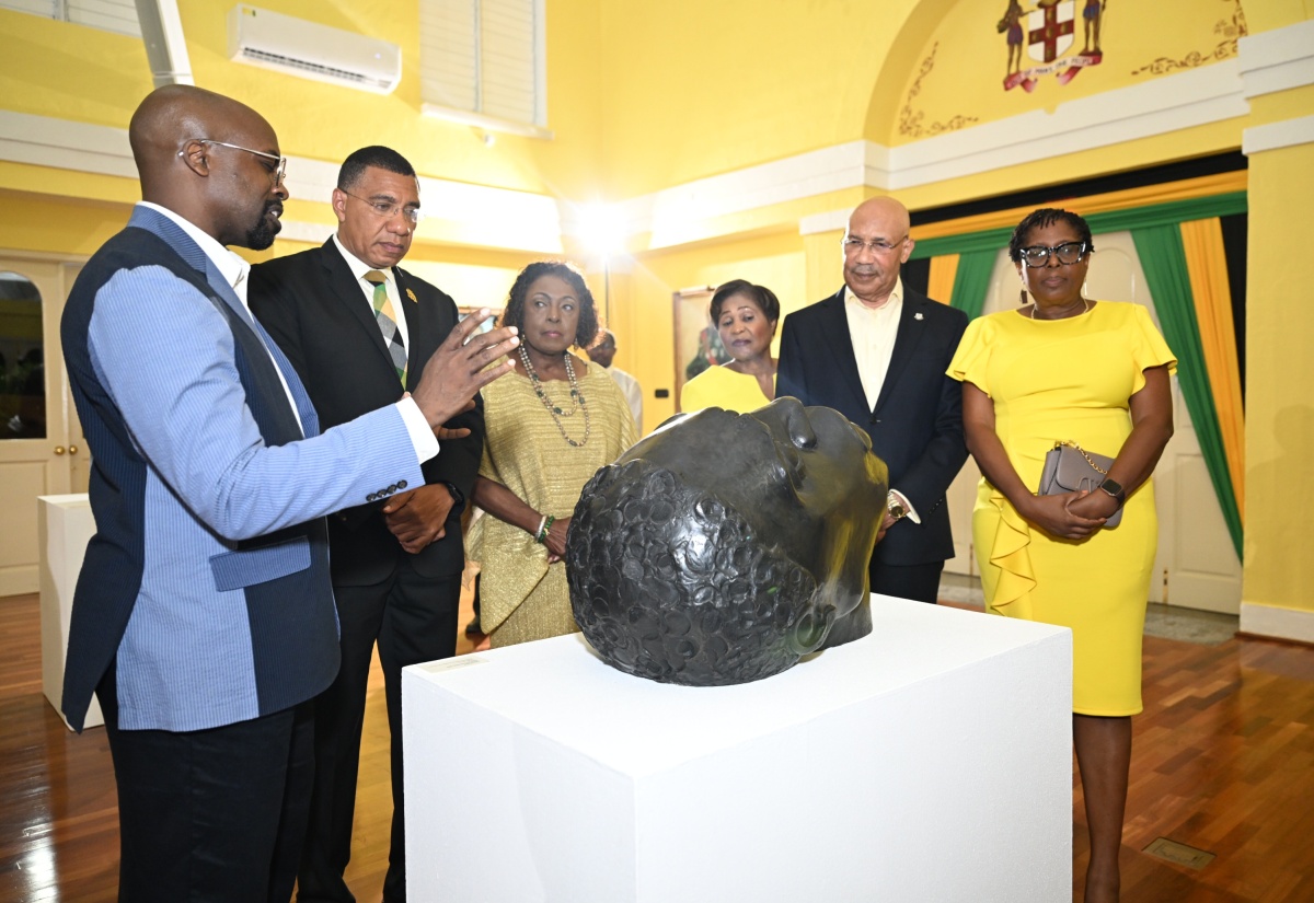 Governor-General, His Excellency the Most Hon. Sir Patrick Allen (second right), and Prime Minister, Dr. the Most Hon. Andrew Holness (second left), listen as Chief Curator at the National Gallery of Jamaica, O’Neil Lawrence (left), provides an overview of one of the pieces displayed during an exhibition coinciding with the Governor General’s reception to celebrate Jamaica’s 63rd Anniversary of Independence. Also listening are (from third left): Minister of Culture, Gender, Entertainment and Sport, Hon. Olivia Grange; Her Excellency, the Most Hon. Lady Allen; and Member of Parliament for St. Andrew South Western, Dr. Angela Brown Burke. The reception was held at King’s House on Thursday (July 24).