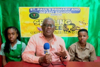 Custos of Manchester, Hon. Garfield Green (centre), offers words of encouragement and support to students of St. Paul’s Primary and Infant School in the parish, during a recent visit to the institution to commend the pupils for their outstanding performance in the Primary Exit Profile (PEP). He is flanked by top students Kerecia Nelson (left) and Dontae Johnson.