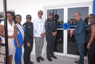 Minister of National Security, Hon. Dr. Horace Chang (second right),  cuts the ribbon to officially open the Green Acres Police Station, in St. Catherine on July 18. Others (from left) are President of the Green Acres Citizens Association, Dr. Vanessa White-Barrow; resident of the area, and Miss Universe finalist, Blaine Wilson; Commander of Area Five Police Division, Acting Assistant Commissioner of Police (ACP), Christopher Phillips; Member of Parliament for St. Catherine West Central, Dr. the Hon. Christopher Tufton; Deputy Commissioner of Police (DCP), Karina Powell-Hood; and Minister of State, in the Ministry of National Security, Hon. Juliet Cuthbert-Flynn.