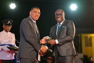 Prime Minister, Dr. the Most Hon. Andrew Holness (left), presents the Medal of Appreciation for Service to Education to Principal of the Montego Bay Community College (MBCC) in St. James, Dr. Darien Henry, during the award ceremony held on May 28 at Jamaica House. 

