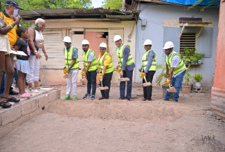 Prime Minister, Dr. the Most Hon. Andrew Holness (left), discusses aspects of the ‘Hibiscus’ housing development in St. Andrew West Central, for which he is the Member of Parliament, with Architectural Designer, Roni-Kaye McLaren (second left), during the contract signing and ground-breaking ceremony at the project site on Thursday (July 10). The development will comprise seven units built at 35 Hibiscus Avenue under the Government’s New Social Housing Programme (NSHP). They are joined by (from third left) Managing Director, Britalex Construction Company, Rohan Kiffin; Permanent Secretary in the Ministry of Economic Growth and Job Creation, Arlene Williams; Senior Director in the Ministry, Richard Cargill; and project beneficiary, Trevor Atkinson.