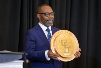 Newly installed President of the Caribbean Court of Justice (CCJ),  Hon. Mr. Justice Winston Anderson, holds the CCJ seal during the swearing-in ceremony held at the Jewel Grande Resort in Montego Bay, St. James, on Sunday (July 6). 

