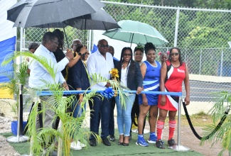 Minister of Tourism, Hon. Edmund Bartlett (third left), cuts the ribbon to officially hand over the rehabilitated Lord's Multipurpose Court in Malcolm Heights, Hanover, on Thursday (July 3). Sharing the moment are Executive Director of the Tourism Product Development Company (TPDCo), Wade Mars (left); Executive Director of the Jamaica Vacations (JamVac), Joy Roberts (second left); Member of Parliament for Hanover Western, Tamika Davis (fourth left) and other stakeholders. 

