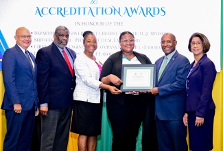 Minister of Industry, Investment and Commerce, Hon. Aubyn Hill (second right), presents Government Chemist at the Department of Government Chemist Analytical and Advisory Branch— Pharmaceutical Laboratory, Yanique Fraser (third right), with an accreditation award. The presentation was made during JANAAC Global Accreditation’s 2025 CEO’s Breakfast and Accreditation Awards, held at the Jamaica Pegasus Hotel in New Kingston on Tuesday (August 26). They are joined by (from left) Chairman, JANAAC Accreditation Council, Simon Roberts; Permanent Secretary in the Ministry of Health and Wellness, Errol Green; Acting Chief Executive Officer (CEO), JANAAC Global Accreditation, Dr. Yvette Castell, and Permanent Secretary in the Ministry of Industry, Investment and Commerce, Sancia Bennett Templer.