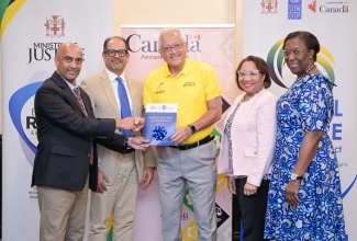 Minister of Justice, Hon. Delroy Chuck (centre), is presented with a copy of Jamaica’s first Gender Strategy and Action Plan for the Justice Sector from United Nations Development Programme (UNDP) Resident Representative, Dr. Kishan Khoday (left), during a ceremony held at the Courtleigh Hotel in New Kingston today (August 27). Observing (from second left) are: Counsellor and Head of Development Cooperation, High Commission of Canada, Shehryar Sarwar; Permanent Secretary in the Ministry of Justice, Grace Ann Stewart McFarlane; and Principal Director at the Bureau of Gender Affairs (BGA) in the Ministry Culture, Gender, Entertainment and Sport, Sharon Coburn Robinson.