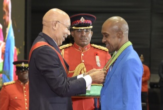 Governor-General, His Excellency the Most Hon. Sir Patrick Allen (left), presents President of the Caribbean Maritime University (CMU), Professor Andrew Spencer, with the insignia for the Order of Distinction in the rank of Commander (CD) during the National Honours and Awards Ceremony on National Heroes Day in 2024

