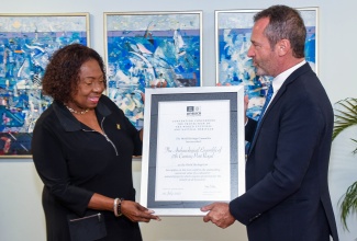 Minister of Culture, Gender, Entertainment and Sport,  Hon. Olivia Grange, receives a Certificate of Inscription classifying Port Royal as a World Heritage Site from Regional Director and Representative of the United Nations Educational, Scientific and Cultural Organization (UNESCO) Cluster Office of the Caribbean, Eric Falt,  during the recent handover ceremony held at the Ministry, in Kingston.

