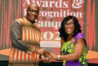 Director and Chief Executive Officer of the Court Administration Division, Tricia Cameron-Anglin, presents Chief Justice, Hon. Bryan Sykes, with the Chief Justice Award for Excellence during the Judiciary of Jamaica Awards and Recognition Banquet on Thursday, August 21, at the Jamaica Pegasus Hotel in New Kingston.