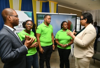 Technical Assistant in the Ministry of Science, Energy, Telecommunications and Transport, Donaree Muirhead (right), and University of Technology, Jamaica (UTech) President, Dr. Kevin Brown (left), converse with student representatives from the 2025 cohort of Huawei Technologies Jamaica’s Seeds for the Future Programme. They are from (second left): UTech students - Zaina Thompson and Christopher Banton; and University of the West Indies (UWI) Mona student, Demaria Walker. The occasion was the programme’s closing ceremony on Friday (August 22) at UTech in Kingston.