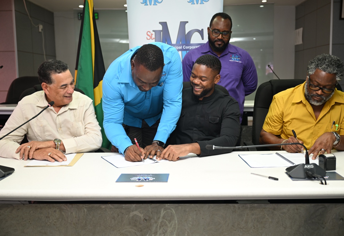 Minister of State in the Office of the Prime Minister (West) and Member of Parliament for St. James Southern, Hon. Homer Davis (left) and Chairman of the St. James Municipal Corporation and Mayor of Montego Bay, Councillor Richard Vernon (second right), look on as Director of Planning and Acting Chief Executive Officer of the St. James Municipal Corporation, Trevian Manning (second left), signs the contract for the $23 million rehabilitation of the Richmond Hill Road in Catadupa, at the Corporation in Montego Bay on Wednesday (July 30). Managing Director of Build Management Technologies and Logistics, Andrew Jeffery (right), also affixes his signature to the contract, while the Corporation’s Acting Chief City Engineer, Yannick Beckford, observes.