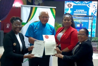 Minister of Justice, Hon. Delroy Chuck (second left), along with Lecturer at the Justice Training Institute (JTI), Chamaele Golding (left), and Custos of St. Catherine, Hon. Icylin M. Golding (right), present new Justice of the Peace (JP), Jillian Wray, with her instruments of appointment, at a commissioning ceremony held on August 20 at the Lighthouse Assembly in Spanish Town, St. Catherine.

