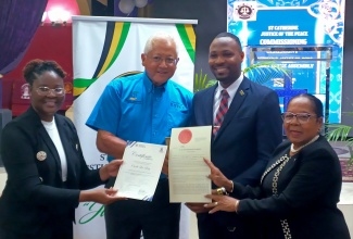 Minister of Justice, Hon. Delroy Chuck (second left), along with Lecturer at the Justice Training Institute (JTI), Chamaele Golding (left), and Custos of St. Catherine, Hon. Icylin M. Golding (right), present new Justice of the Peace (JP), Orville Levy, with his instruments of appointment, at a commissioning ceremony held recently at the Lighthouse Assembly in Spanish Town, St. Catherine.


