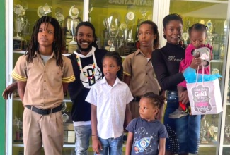 Old Harbour High School students Rajiv Lovelace (left) and Derrick Menzie (third right), who have received a donation of laptops and other educational supplies from the Pollyanna Project, share a moment with their parents Donavan Menzie (second left), and Trisha Linton (right) and their siblings, at the presentation ceremony held at the institution in St. Catherine on August 11.

