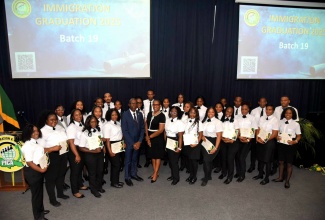 Permanent Secretary in the Ministry of National Security and Chief Immigration Officer, Ambassador Alison Stone Roofe (fourth left, front row), and Chief Executive Officer, Passport, Immigration and Citizenship Agency (PICA), Garth Williams (third left, front row), share a photo opportunity with the 19th batch of immigration officer graduates of PICA’s training programme. The occasion was Thursday’s (August 14) graduation ceremony at the Jamaica Defence Force Caribbean Military Academy, Up Park Camp, Kingston.

