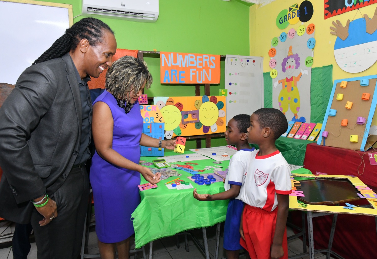 Minister of Education, Skills, Youth and Information, Dr. the Hon. Dana Morris Dixon, and State Minister in the Ministry of Foreign Affairs and Foreign Trade, Hon. Alando Terrelonge, interact with students of Gregory Park Primary School in St. Catherine recently.

