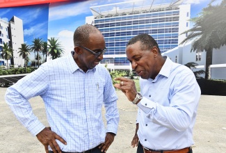 Chairman of the University Hospital of the West Indies (UHWI), Patrick Hylton (left), in discussion with Medical Officer of Health at the Hospital, Dr. Carl Bruce, at the recent breaking of ground for a state-of-the-art medical tower.

