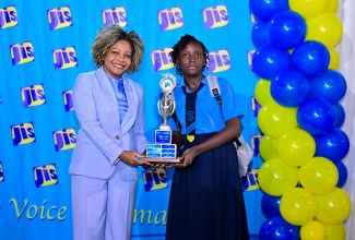 Minister of Education, Skills, Youth and Information, Senator Dr. the Hon. Dana Morris Dixon, presents Kamili Forrester of Goshen Primary in St. Elizabeth with the first-place trophy in the essay category of the 2024 Jamaica Information Service (JIS) Heritage Competition. The awards ceremony was held at the Terra Nova All-Suite Hotel in Kingston.

