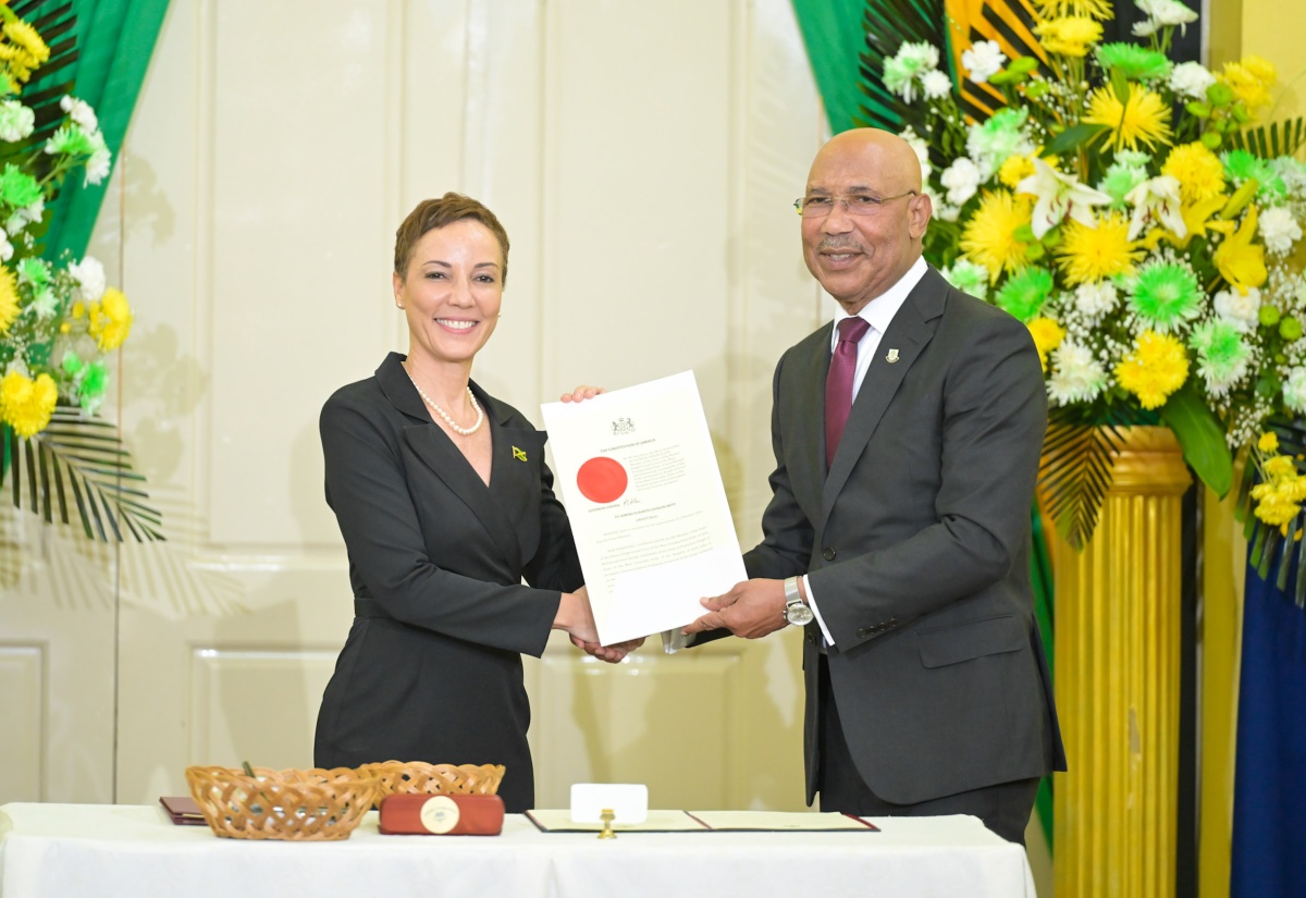 Governor-General, His Excellency the Most Hon. Sir Patrick Allen, presents the Instrument of Appointment to 
Minister of Foreign Affairs and Foreign Trade, Senator the Hon. Kamina Johnson Smith (left), during the swearing-in ceremony for Cabinet Ministers at King’s House on September 17.