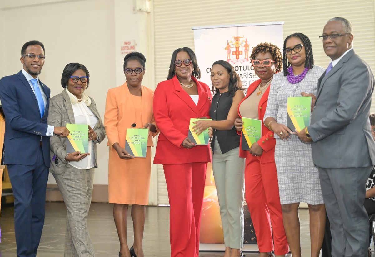 Custos of Manchester, Hon. Garfield Green (right), Regional Director at the Ministry of Education, Skills, Youth and Information, Susan Nelson-Smith (second right), and other officials, display copies of the Constitution of Jamaica, during a ceremony for the reopening of schools in the parish, at deCarteret College in the parish on September 12.